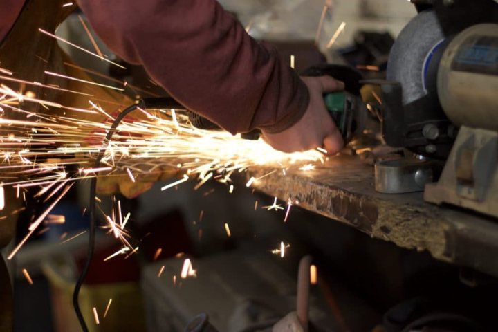 man grinding metal